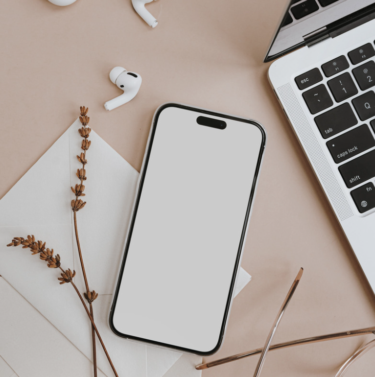 Mobile phone, laptop and earphones on desk of a social media manager