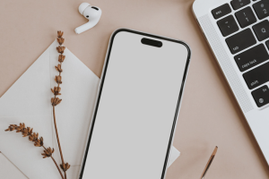 Mobile phone, laptop and earphones on desk of a social media manager